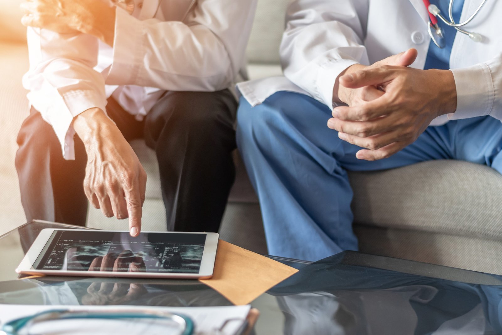 Two healthcare professionals discussing medical images on a tablet.