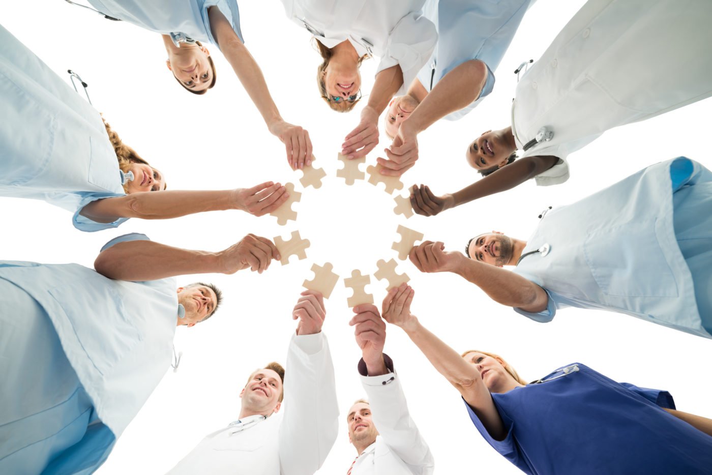Healthcare professionals collaborating with puzzle pieces, symbolizing teamwork.