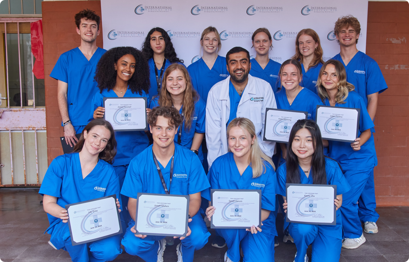 A group of people in blue scrubs holding certificates, possibly related to optometry internships.