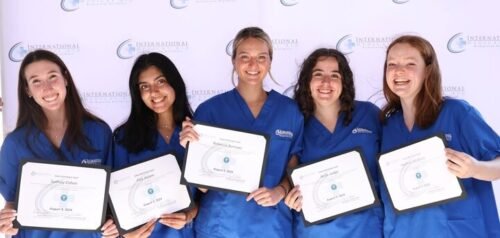 A group of people wearing blue scrubs are holding certificates, possibly related to medical internship achievements.