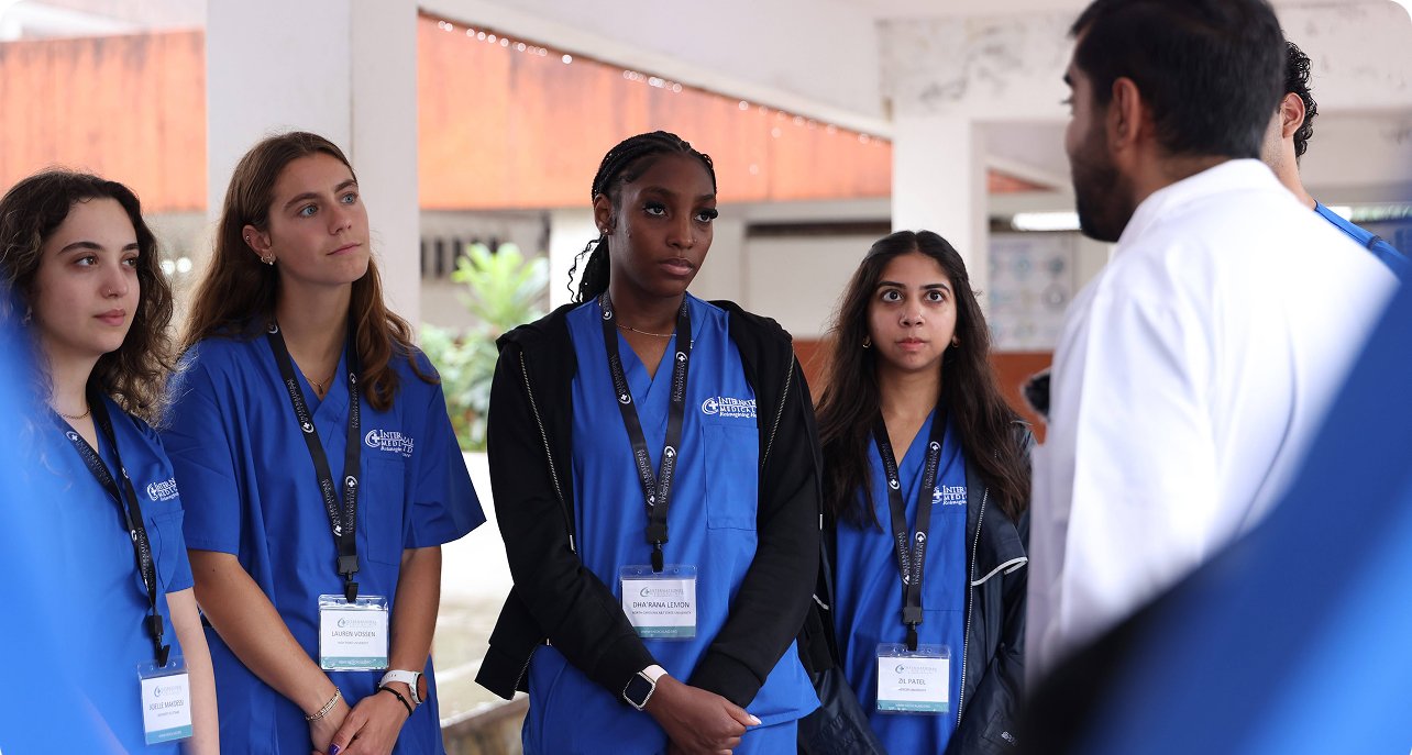 A group in blue uniforms listens to a person in white. High school healthcare internships seem relevant.